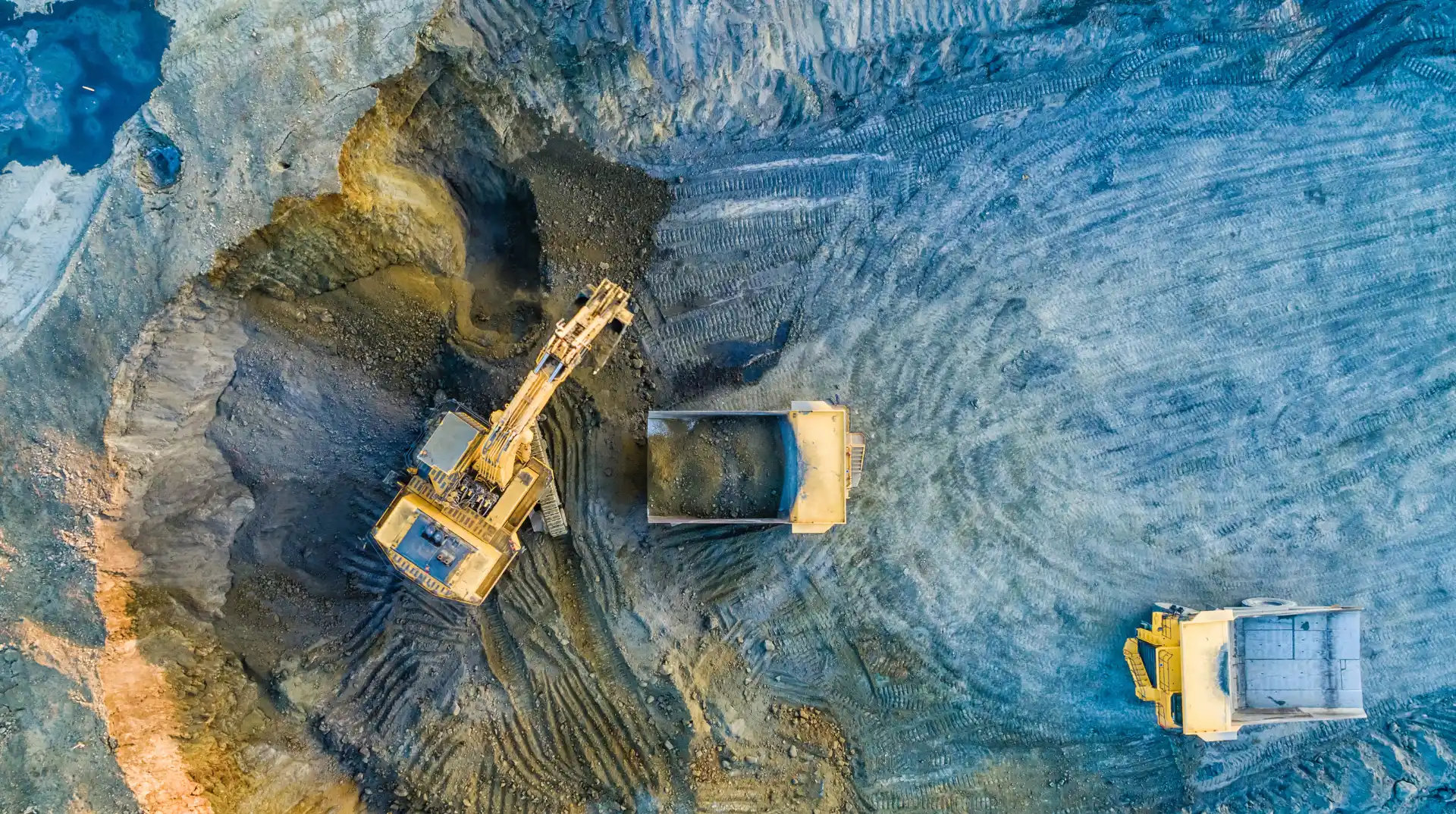 A top-down view of a large excavator working in a pit.